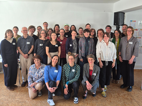 Gruppe von circa 30 Menschen  für Gruppenfoto in einem Raum