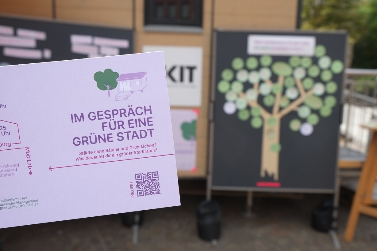 Flyer mit der Aufschrift „Im Gespräch für eine grüne Stadt“ vor einem Event-Plakat.